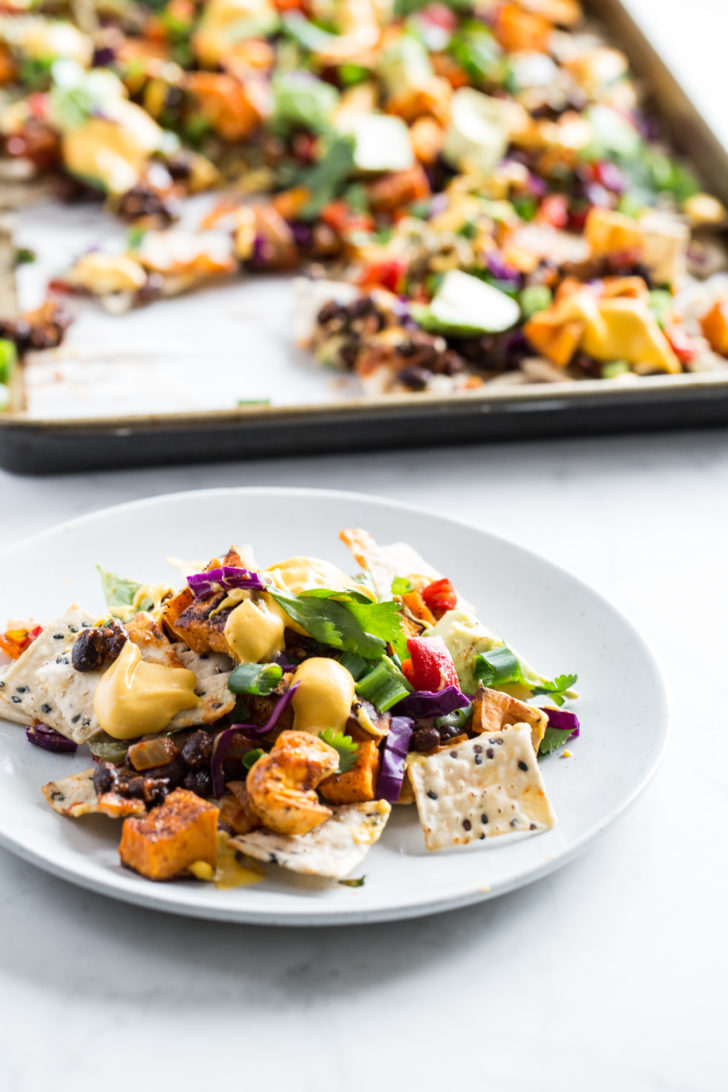 Plate of nachos beside pan