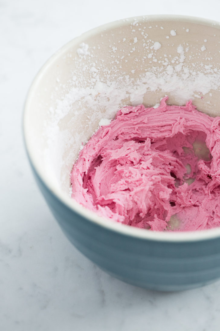 Pink frosting in teal bowl